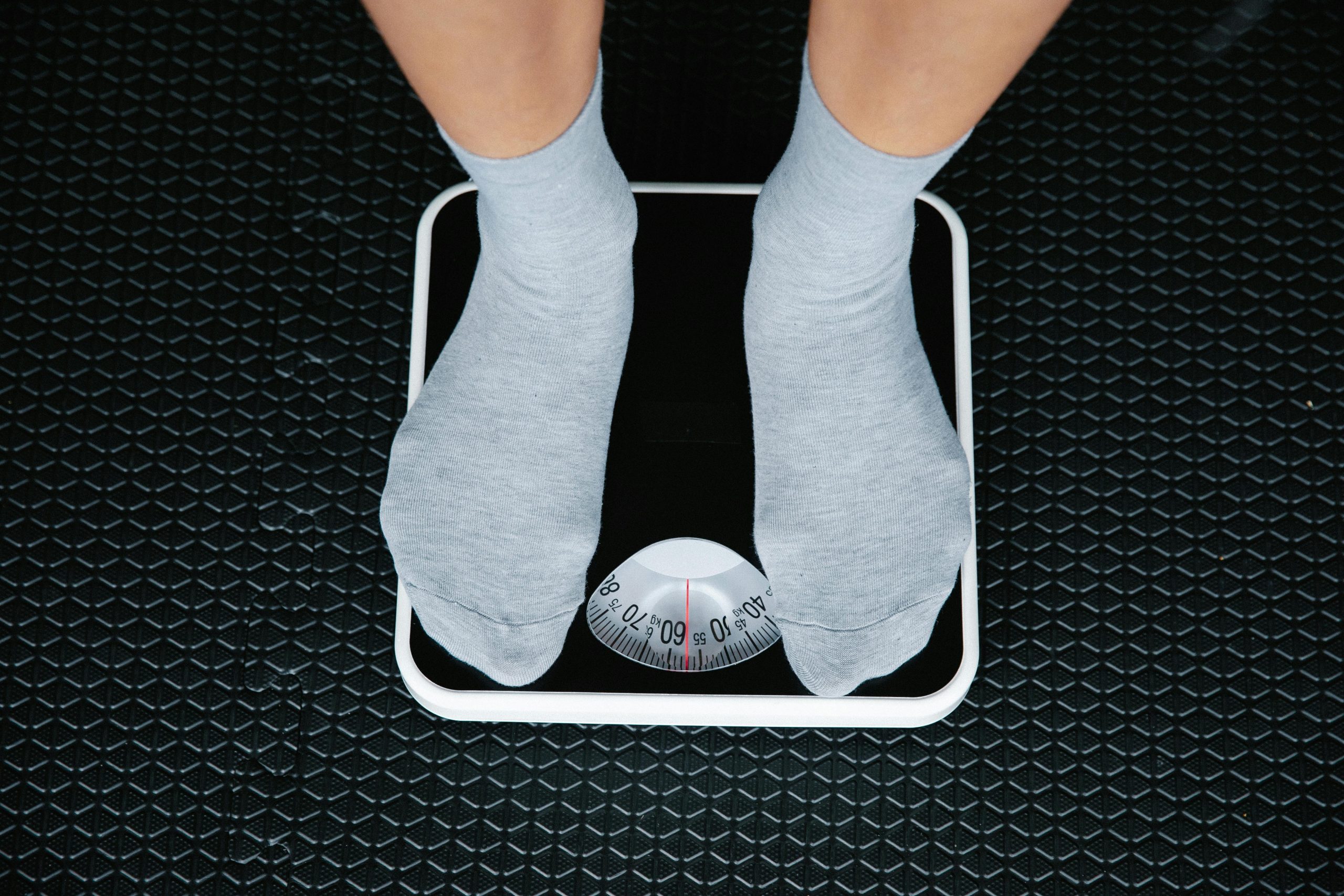 Person standing on a scale to measure weight loss