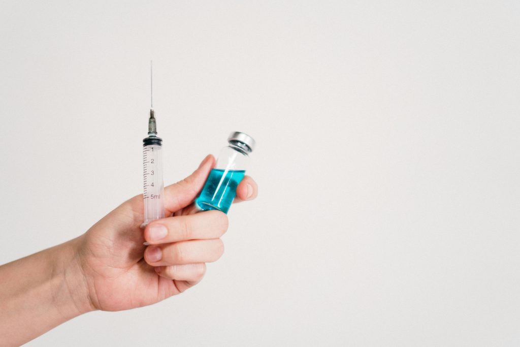 Person holding a syringe for peptide injections