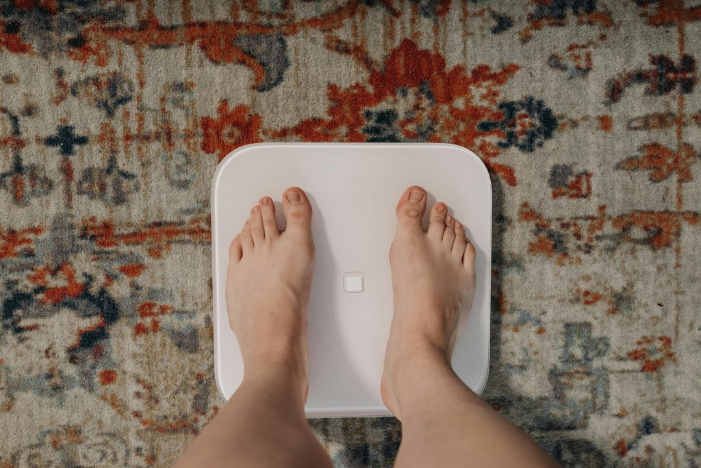 Person standing on scale to measure weight loss