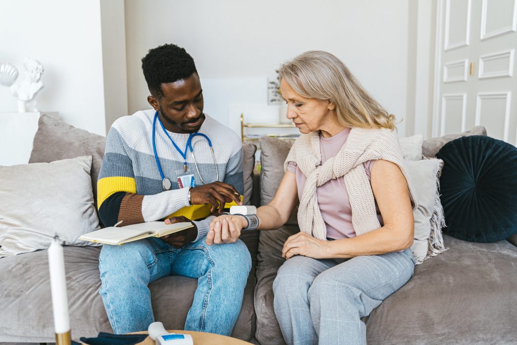Woman having blood pressure taken on a couch