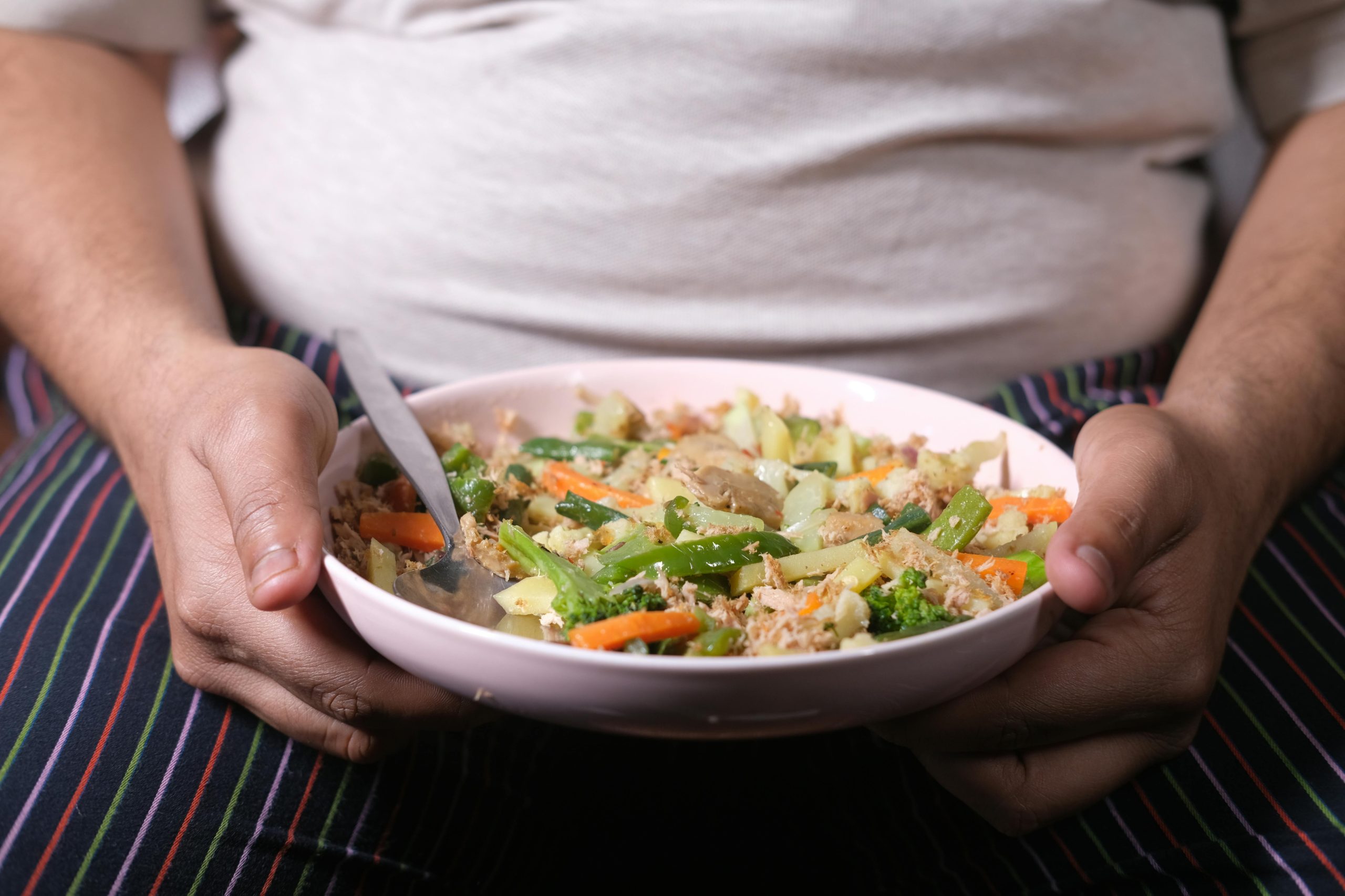 Overweight person holding a plate of food