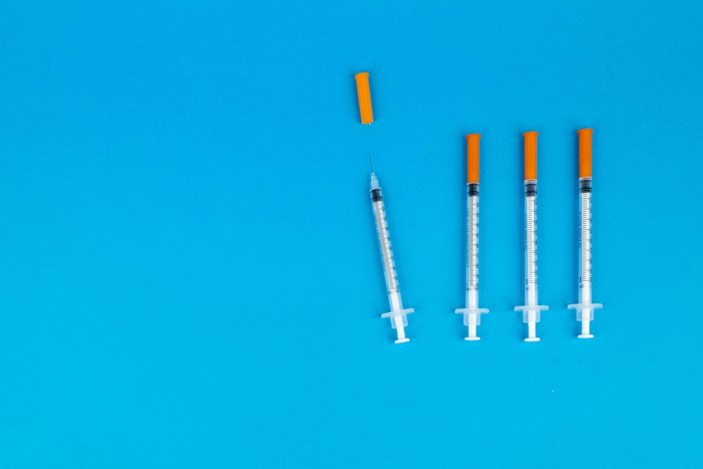 Syringes lined up on a blue background